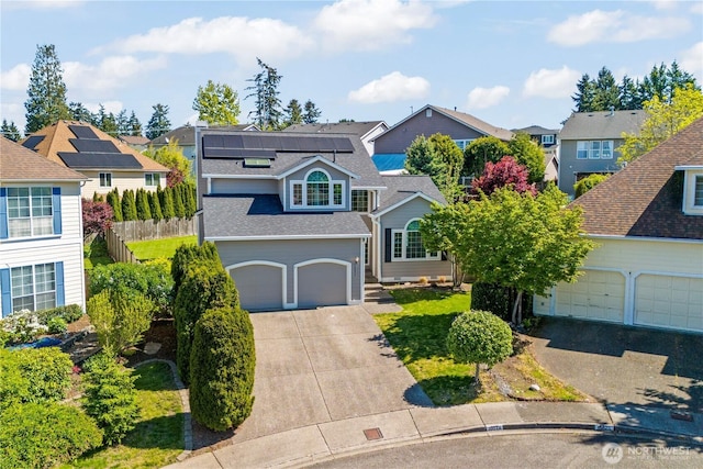 traditional-style home with driveway, a residential view, solar panels, roof with shingles, and an attached garage