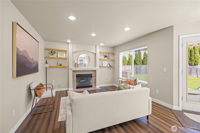 living room with dark wood-style floors, healthy amount of natural light, recessed lighting, a fireplace with flush hearth, and baseboards
