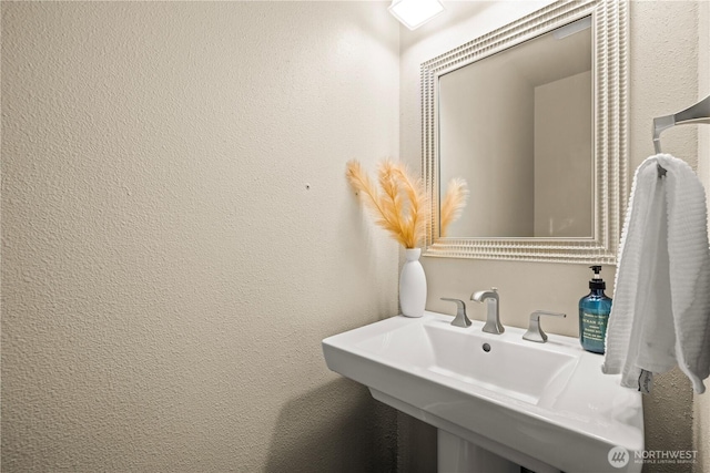 bathroom with a sink and a textured wall