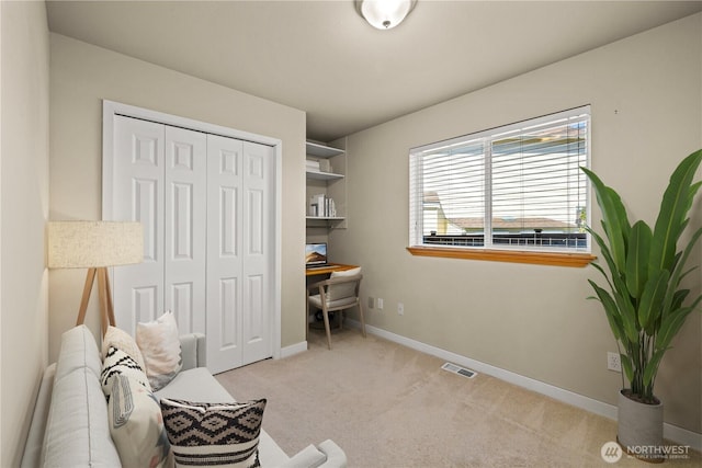 living area featuring carpet flooring, baseboards, and a desk