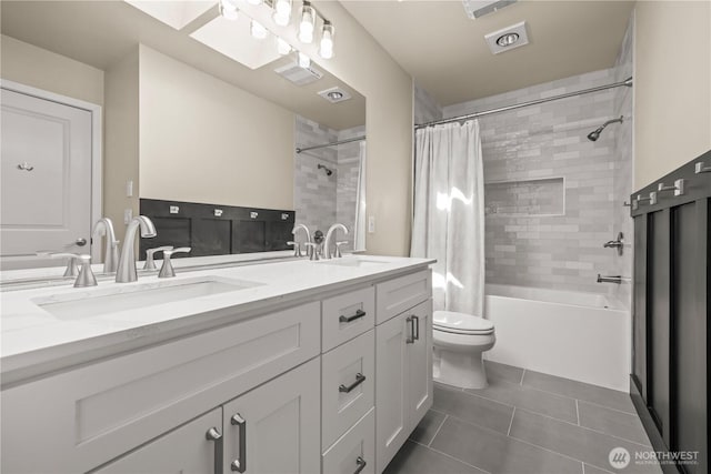 bathroom with tile patterned floors, toilet, double vanity, and shower / bath combo with shower curtain