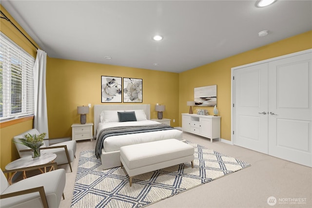 bedroom with light colored carpet, recessed lighting, and a closet
