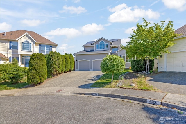 view of front of home with asphalt driveway and solar panels