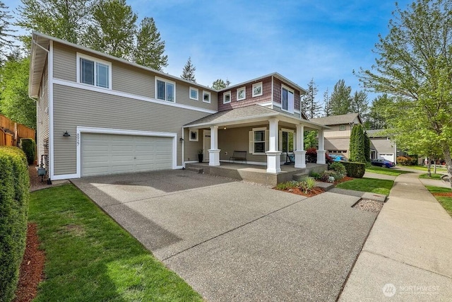 view of front of property with covered porch, an attached garage, driveway, and fence