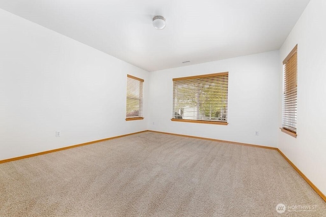 empty room with baseboards and light carpet