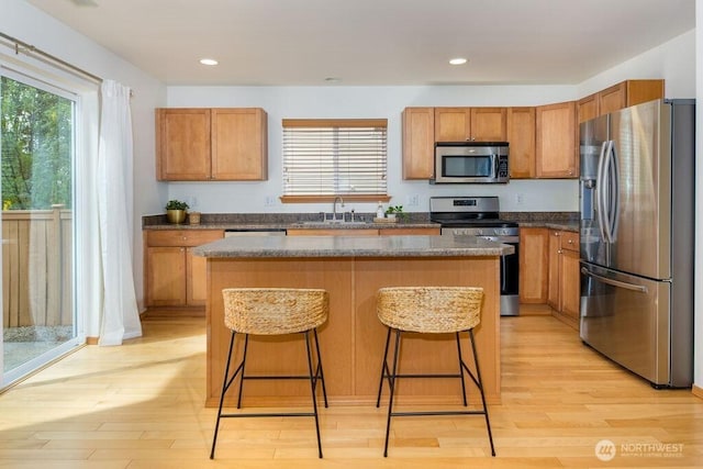 kitchen featuring stainless steel appliances, light wood-type flooring, a sink, healthy amount of natural light, and recessed lighting