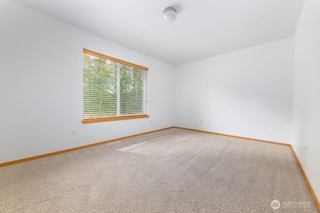 carpeted empty room with baseboards