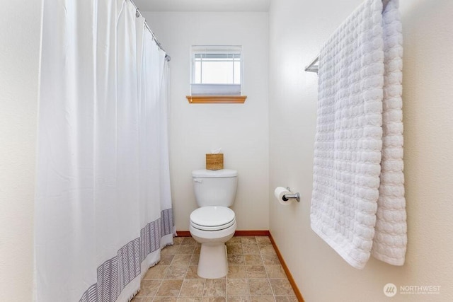 full bathroom with toilet, baseboards, and a shower with shower curtain