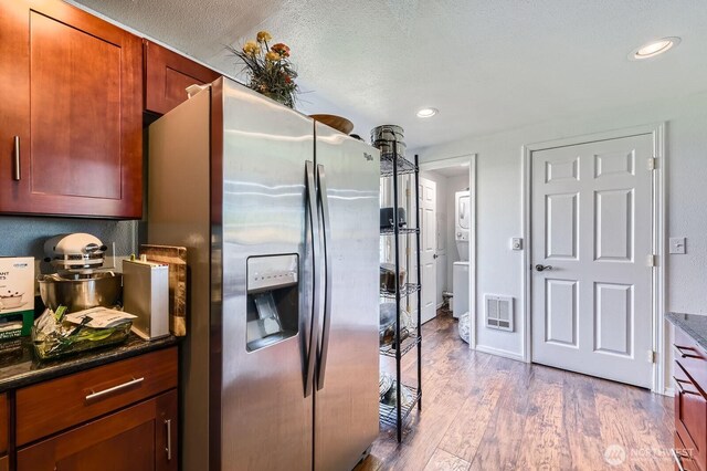 4503 Yew Ln SW, Lakewood, WA 98499 - kitchen with stainless steel fridge with ice dispenser, wood finished floors, recessed lighting, and dark stone counters