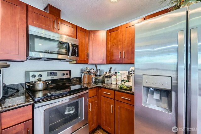 4503 Yew Ln SW, Lakewood, WA 98499 - kitchen featuring stainless steel appliances, dark stone counters, a textured ceiling, and brown cabinets