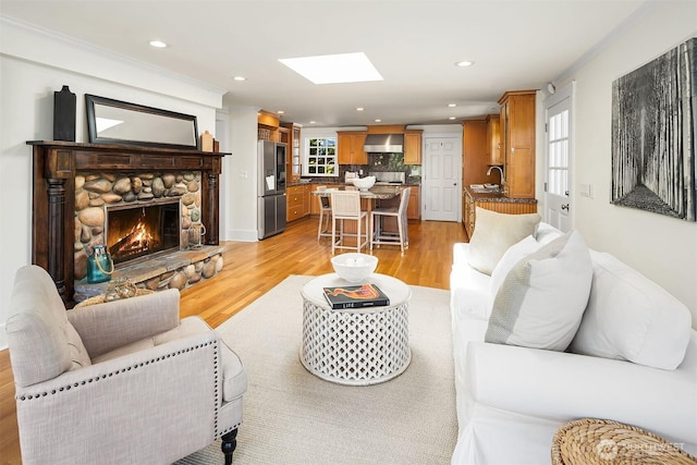3204 Evergreen Point Rd, Medina, WA 98039 - living area featuring light wood-type flooring, a skylight, recessed lighting, and a stone fireplace