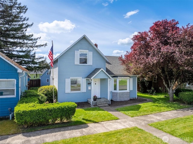 166 SW Lewis St, Chehalis, WA 98532 - view of front of home with a front lawn, a shingled roof, and a chimney
