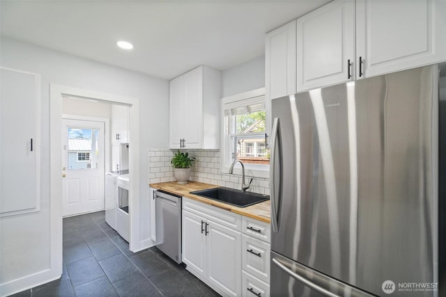 166 SW Lewis St, Chehalis, WA 98532 - kitchen featuring stainless steel appliances, a sink, wooden counters, washing machine and clothes dryer, and white cabinets
