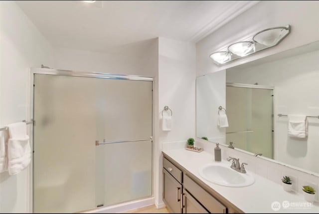 full bathroom with a stall shower and vanity