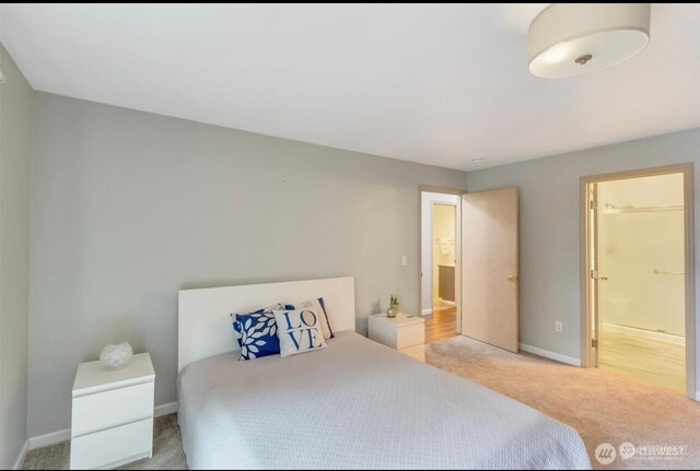 bedroom featuring light carpet and baseboards