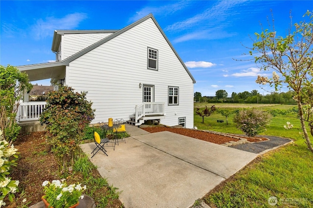 back of property featuring a patio and a yard
