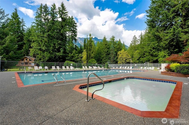 community pool with fence and a mountain view