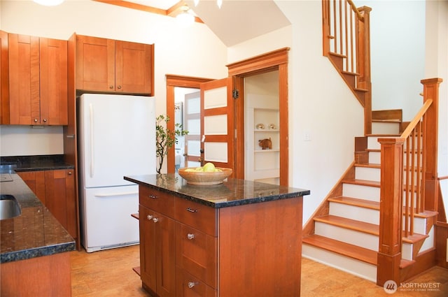 123 24th Ave, Seattle, WA 98122 - kitchen featuring freestanding refrigerator, dark stone countertops, a center island, and brown cabinets