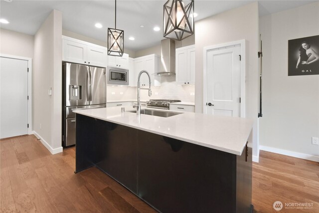 1086 Collier Pl SW, Issaquah, WA 98027 - kitchen with stainless steel appliances, wall chimney exhaust hood, wood finished floors, baseboards, and recessed lighting
