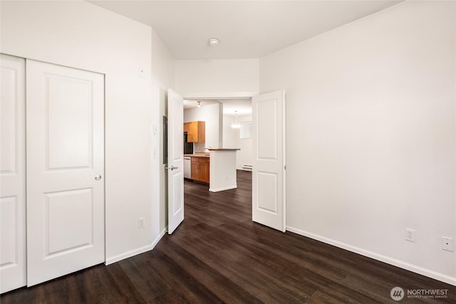 21450 40th Pl S Unit A, Seatac, WA 98198 - unfurnished bedroom featuring dark wood finished floors, baseboards, a baseboard radiator, and a closet