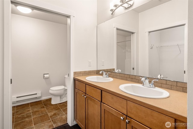 21450 40th Pl S Unit A, Seatac, WA 98198 - bathroom featuring a baseboard heating unit, toilet, double vanity, and a spacious closet