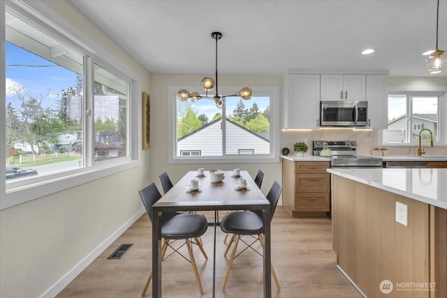 1246 SW 148th St, Burien, WA 98166 - dining room featuring healthy amount of natural light, light wood finished floors, a chandelier, baseboards, and recessed lighting