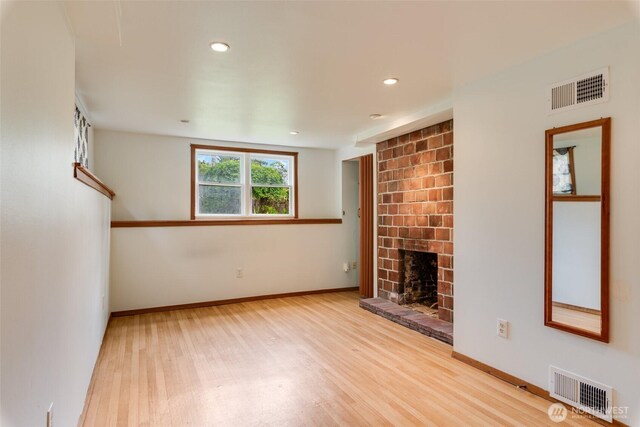 414 W Wyandotte Ave, Shelton, WA 98584 - unfurnished living room featuring wood finished floors, a brick fireplace, and recessed lighting