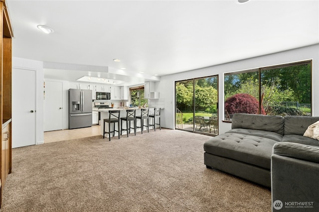 living area featuring light carpet and recessed lighting