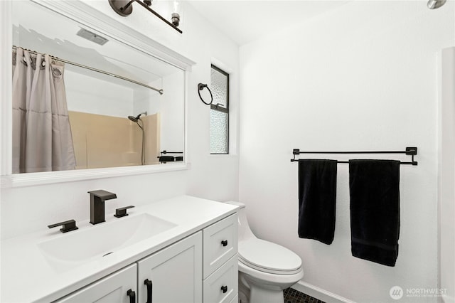 bathroom featuring toilet, vanity, and a shower with curtain