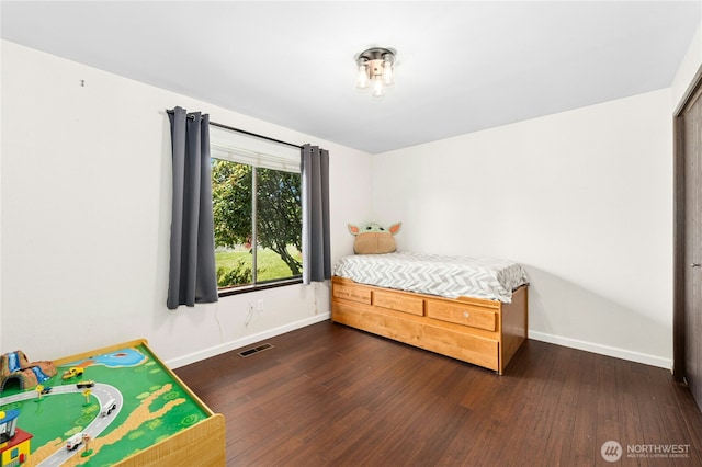 bedroom with baseboards and wood finished floors