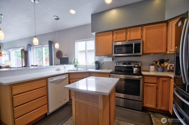 4509 Waterford Ln SE, Lacey, WA 98503 - kitchen featuring appliances with stainless steel finishes, a sink, a peninsula, light countertops, and pendant lighting