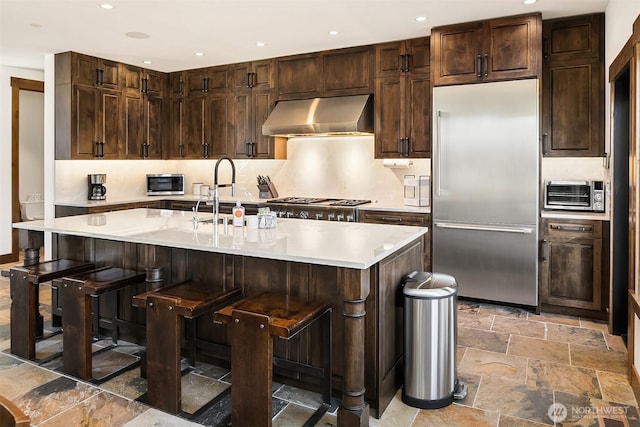 350 Kings Ct, Cle Elum, WA 98922 - kitchen featuring appliances with stainless steel finishes, under cabinet range hood, stone tile flooring, light countertops, and a sink