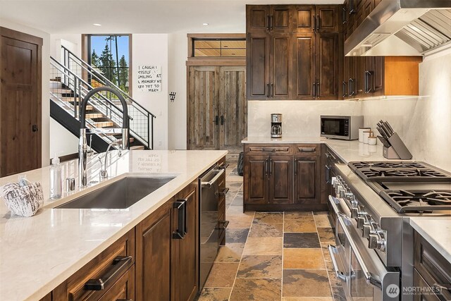 350 Kings Ct, Cle Elum, WA 98922 - kitchen with wall chimney range hood, stainless steel appliances, a sink, light countertops, and stone tile flooring