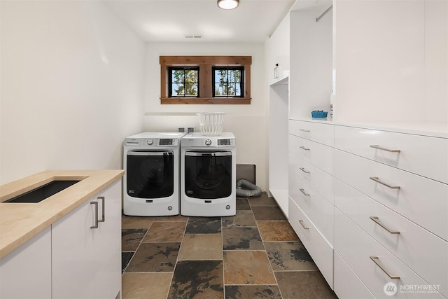 350 Kings Ct, Cle Elum, WA 98922 - laundry room featuring washing machine and dryer, stone tile flooring, and cabinet space