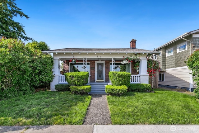 319 1st St, Auburn, WA 98002 - view of front of home with covered porch, a chimney, and a front yard