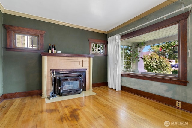 319 1st St, Auburn, WA 98002 - unfurnished living room featuring baseboards, wood-type flooring, a brick fireplace, crown molding, and healthy amount of natural light