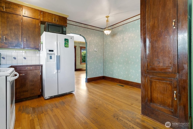 319 1st St, Auburn, WA 98002 - kitchen with white appliances, hardwood / wood-style floors, arched walkways, ornamental molding, and wallpapered walls