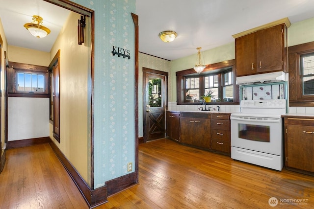 319 1st St, Auburn, WA 98002 - kitchen featuring white electric range, under cabinet range hood, hardwood / wood-style flooring, wallpapered walls, and light countertops