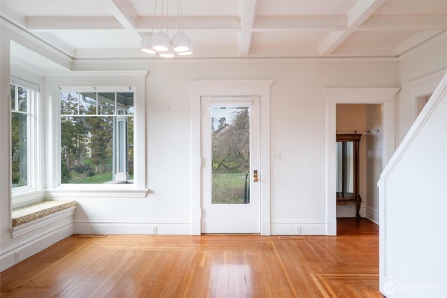 unfurnished dining area with coffered ceiling, plenty of natural light, a chandelier, beamed ceiling, and baseboards