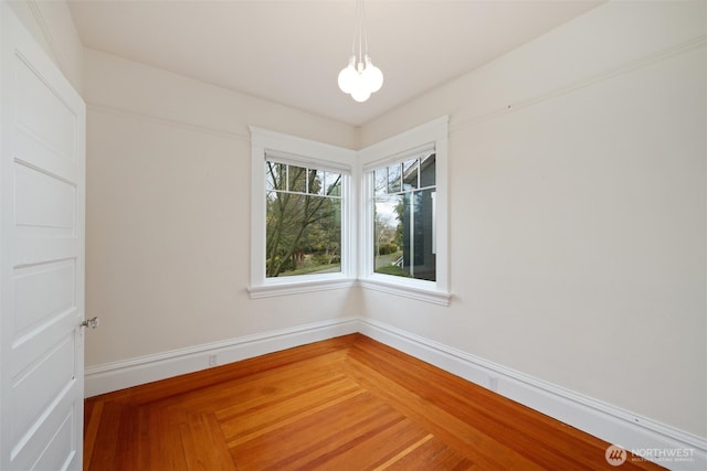 unfurnished room with baseboards