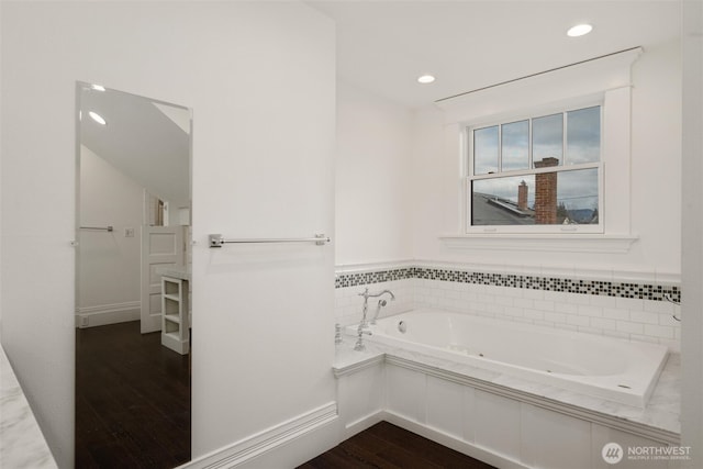 full bathroom with wood finished floors, a tub with jets, and recessed lighting