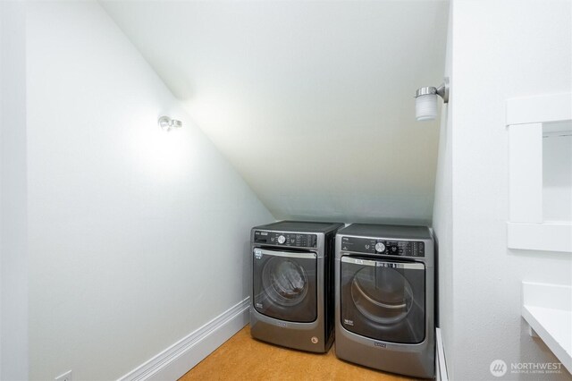 clothes washing area featuring washer and dryer and baseboards