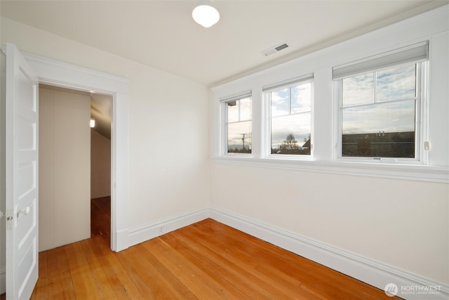 empty room with light wood-style flooring and baseboards