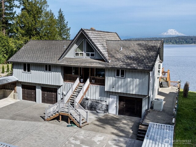 view of front facade with stairs, driveway, a garage, and a tiled roof