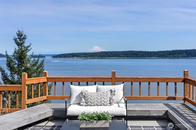 wooden terrace with a water view, an outdoor hangout area, and a forest view