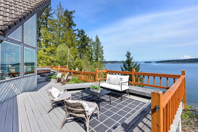 deck featuring a water view and an outdoor living space
