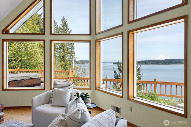 sunroom with a water view and wood finished floors