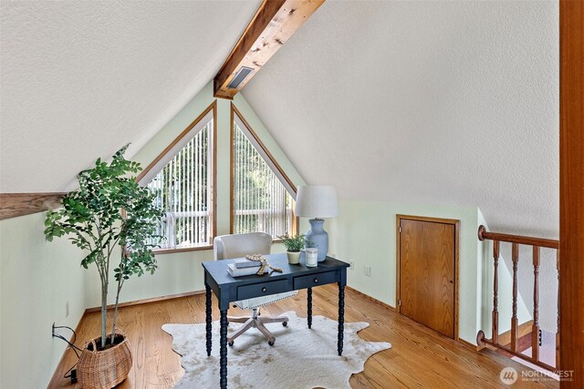 office area featuring light wood-type flooring and a textured ceiling