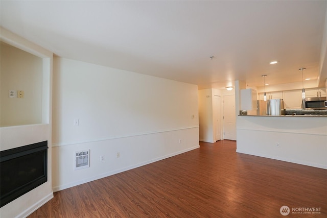 18621 Blueberry Ln Unit B206, Monroe, WA 98272 - unfurnished living room featuring dark wood-style flooring, recessed lighting, baseboards, and a glass covered fireplace