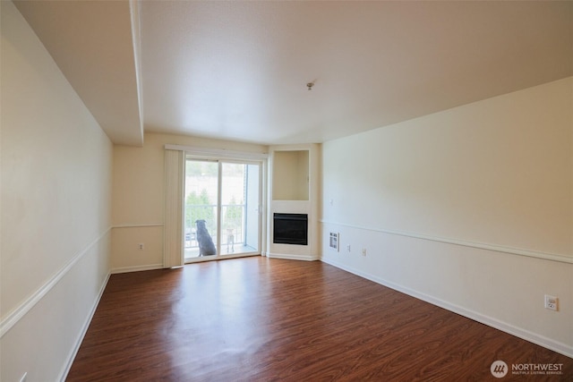 18621 Blueberry Ln Unit B206, Monroe, WA 98272 - unfurnished living room with dark wood-style flooring, a glass covered fireplace, and baseboards
